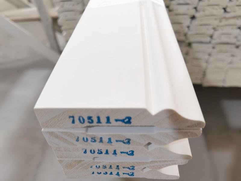 Stacked solid wood moulding profiles showing natural timber grain, ready for export packaging at Goodwood Mouldings