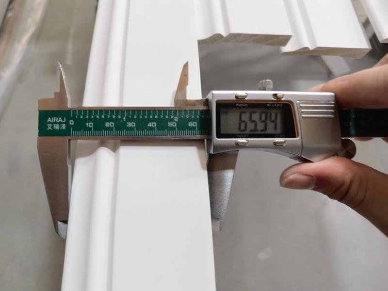 Quality control inspector measuring wood moulding dimensions on a production line at Goodwood's Xiamen facility