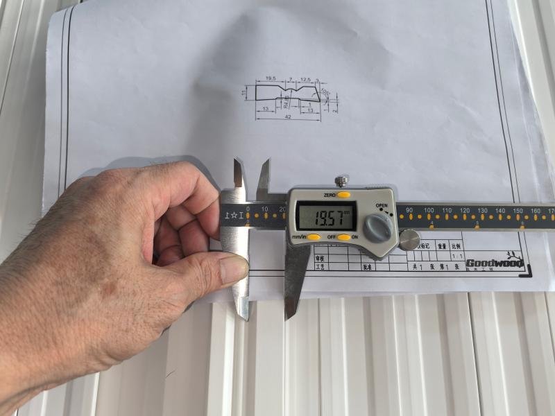 Quality control inspector checking custom wood moulding dimensions against specification at Goodwood factory