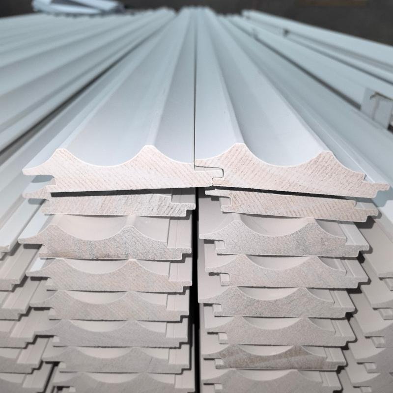 Close-up of CNC-milled custom wood moulding cross-section profiles showing complex multi-radius geometry, produced at Goodwood Mouldings